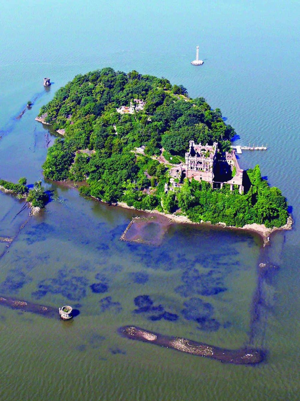 Aerial view of Quest for Directions island with historic castle, lush greenery, and surrounding water.