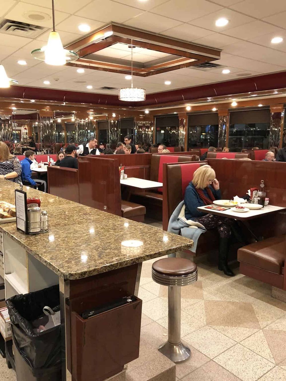 Comfortable American restaurant dining area with red booths and warm lighting.