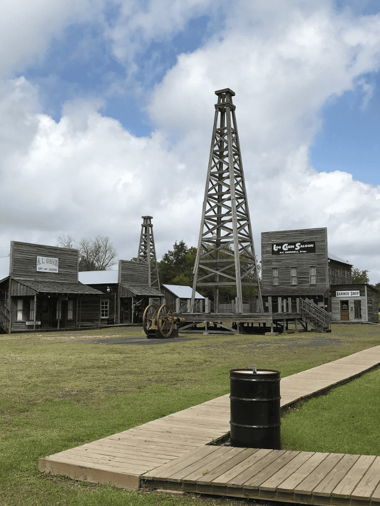 Old Western Frontier Town replica with wooden buildings and mining towers, perfect for adventure gaming and exploration.