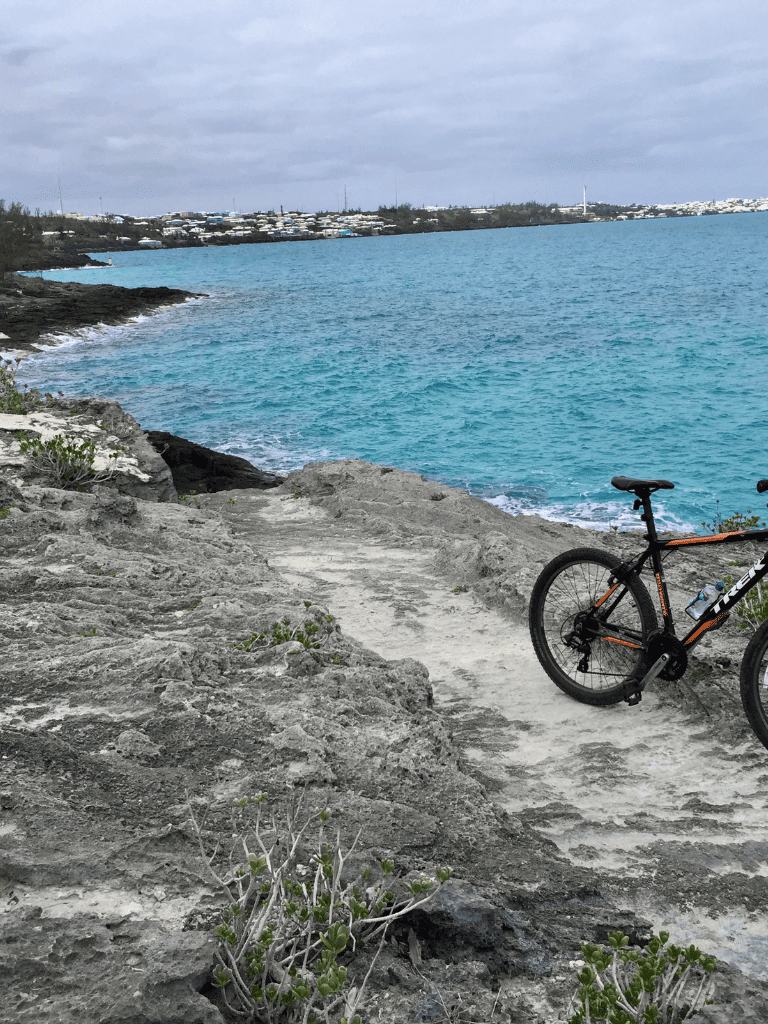 Seaside bike trail overlooking turquoise ocean and rocky coastlines.