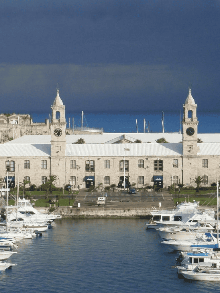 Elegant harbor with historic clock towers and luxury boats in a coastal city.