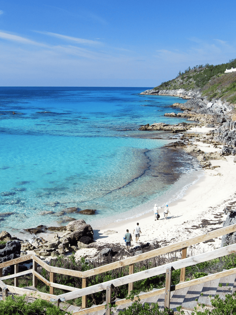 Stunning coastal scene with clear blue waters and rocky shoreline at a beach destination.