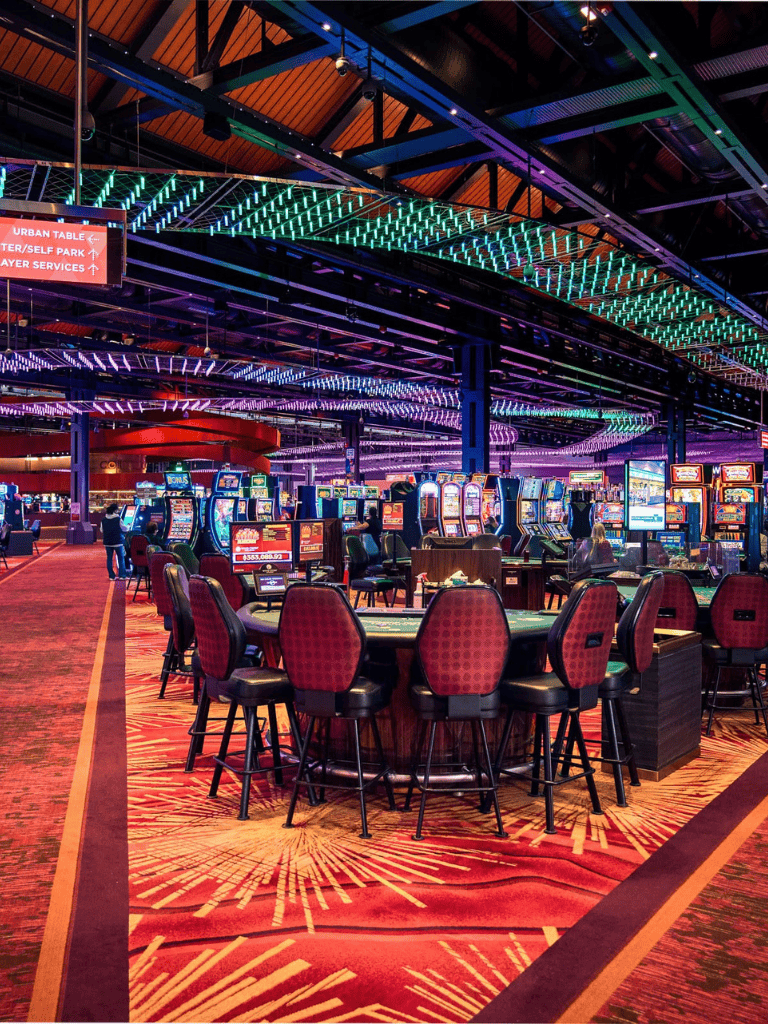 Bright casino gaming area with slot machines and vibrant colorful lighting at Quest For Directions.