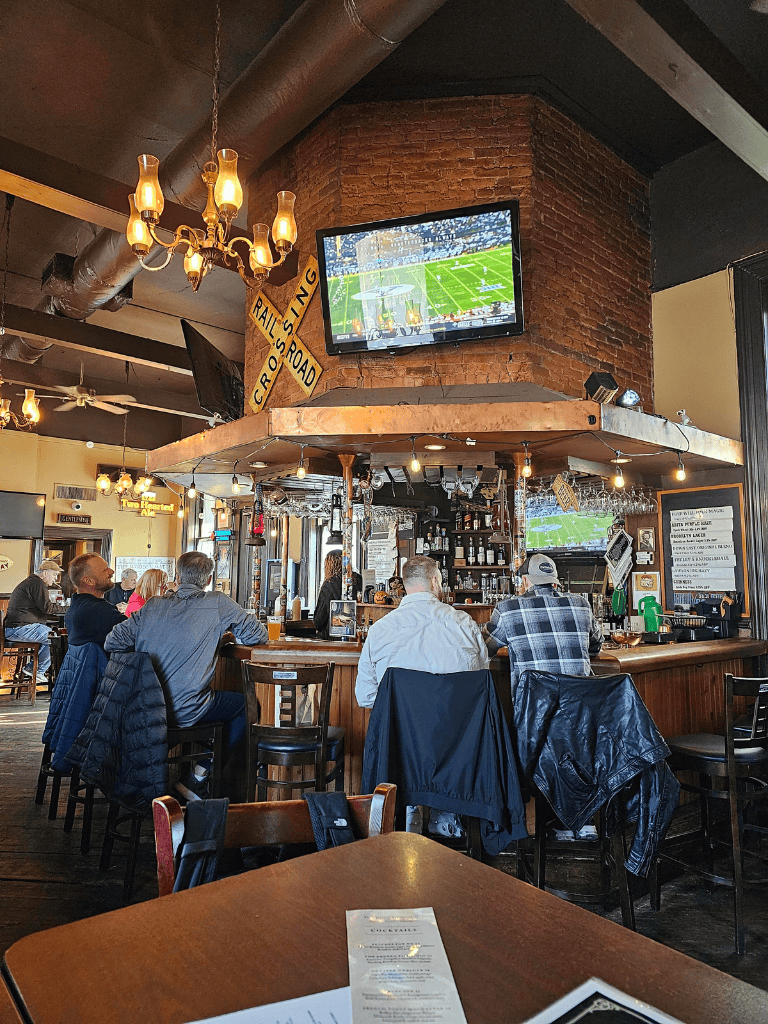 Watching football at a cozy bar with multiple screens and a lively atmosphere.