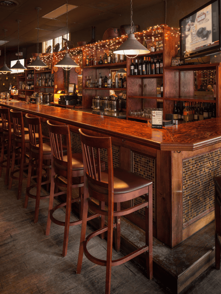 Cozy whiskey bar with warm wood interior and ambient lighting.