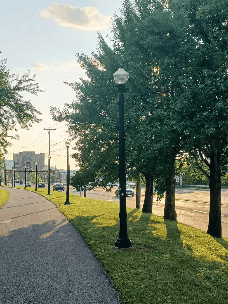 Bright street lights along a scenic sidewalk in an urban area, perfect for city navigation.