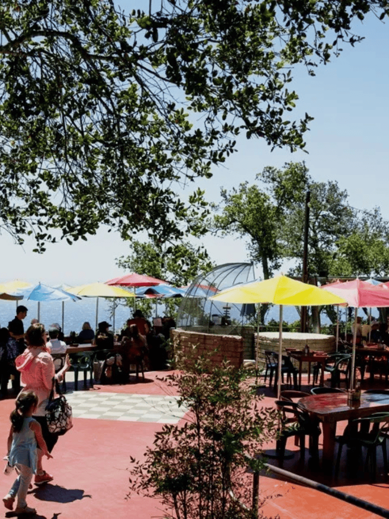 Balcony dining area with colorful umbrellas and scenic mountain views at Quest for Directions.