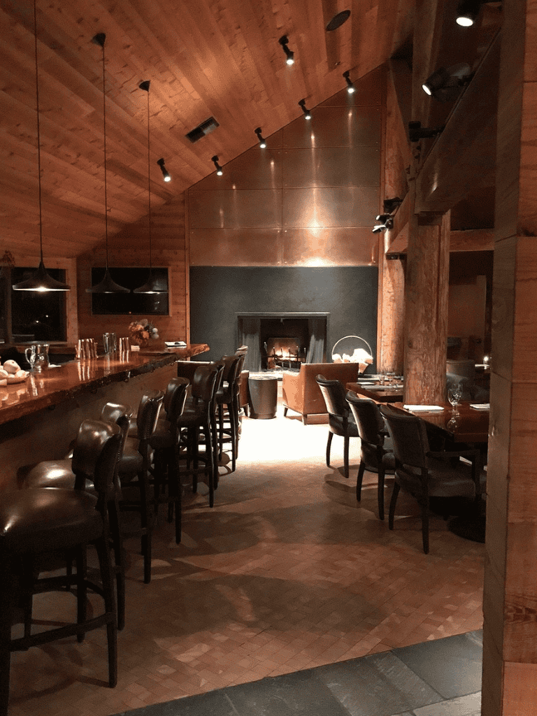 Cozy restaurant interior with wood accents and a fireplace for a warm dining experience.