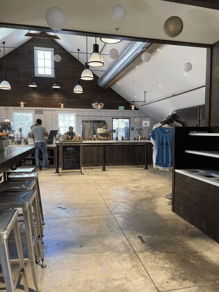 Modern coffee shop interior with industrial design, pendant lighting, and seating area.