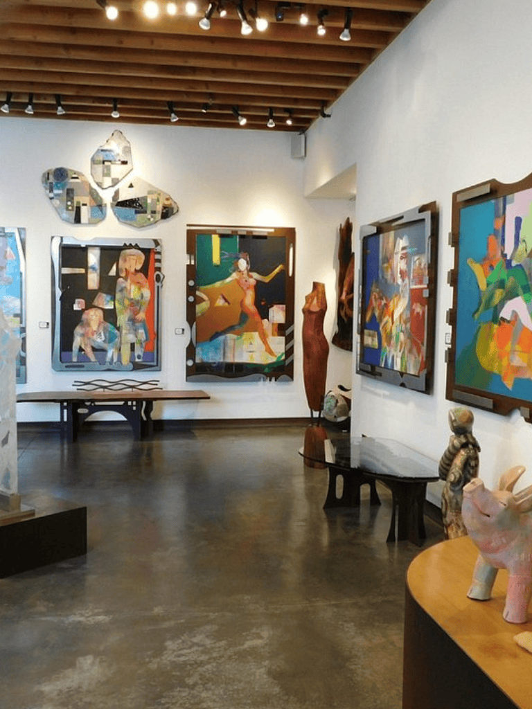 Colorful abstract art gallery showcasing vibrant paintings and sculptures in a modern art space.