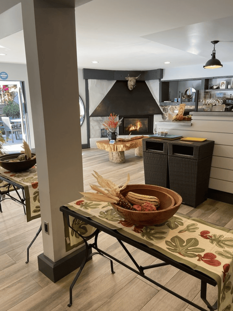 Fireplace with modern decor and rustic accents in cozy restaurant setting.