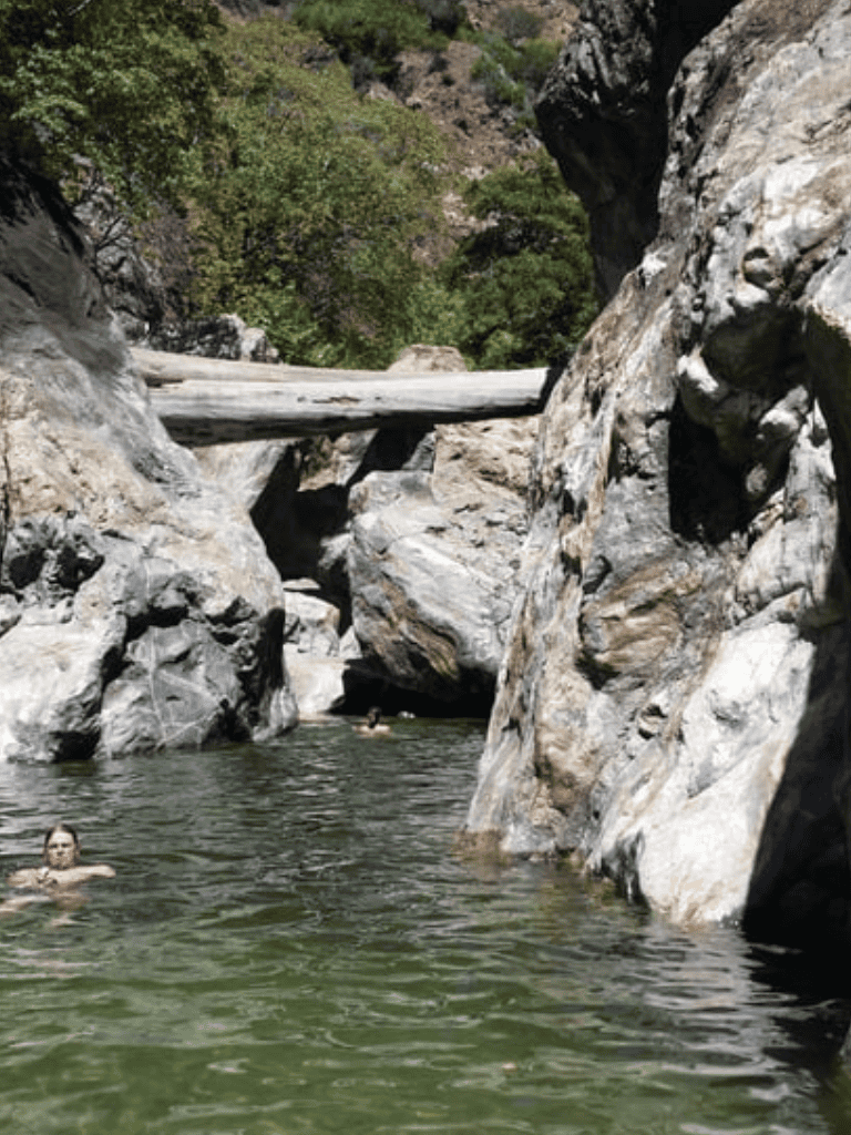Serene canyon swimming hole with rocky formations and clear water, ideal for outdoor adventure and nature exploration.