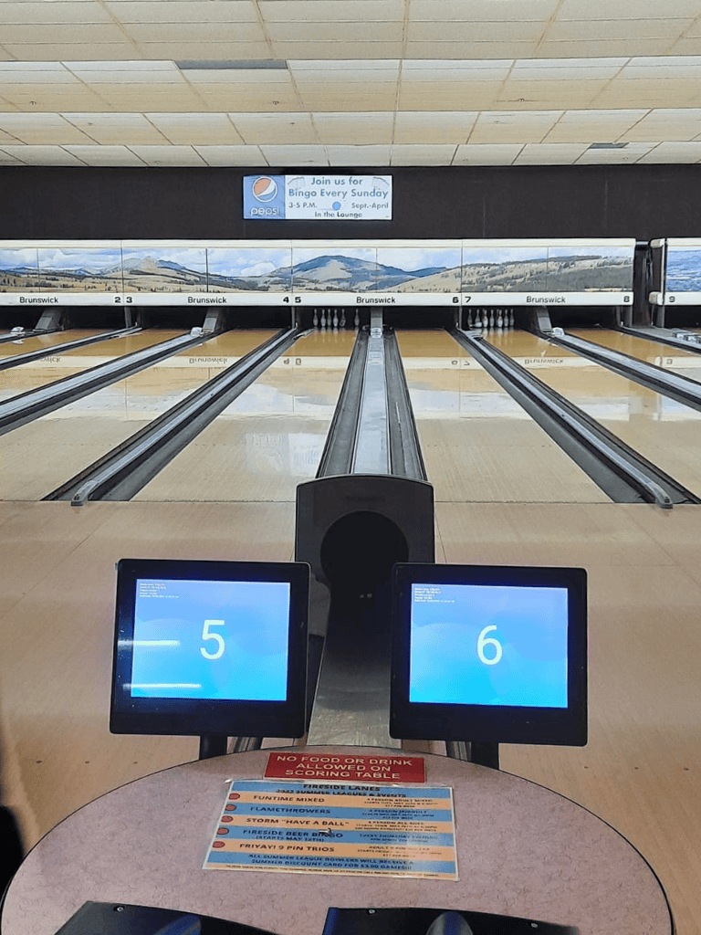 Modern bowling alley with electronic scoring screens and digital lane numbers, offering a fun recreational experience.