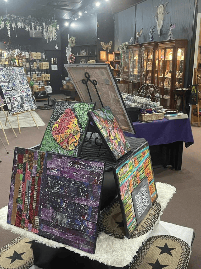 Colorful modern art paintings displayed in an art shop or gallery setting.