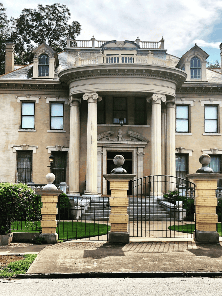 Elegant historic mansion with grand columns and well-maintained front yard, perfect for architectural exploration.