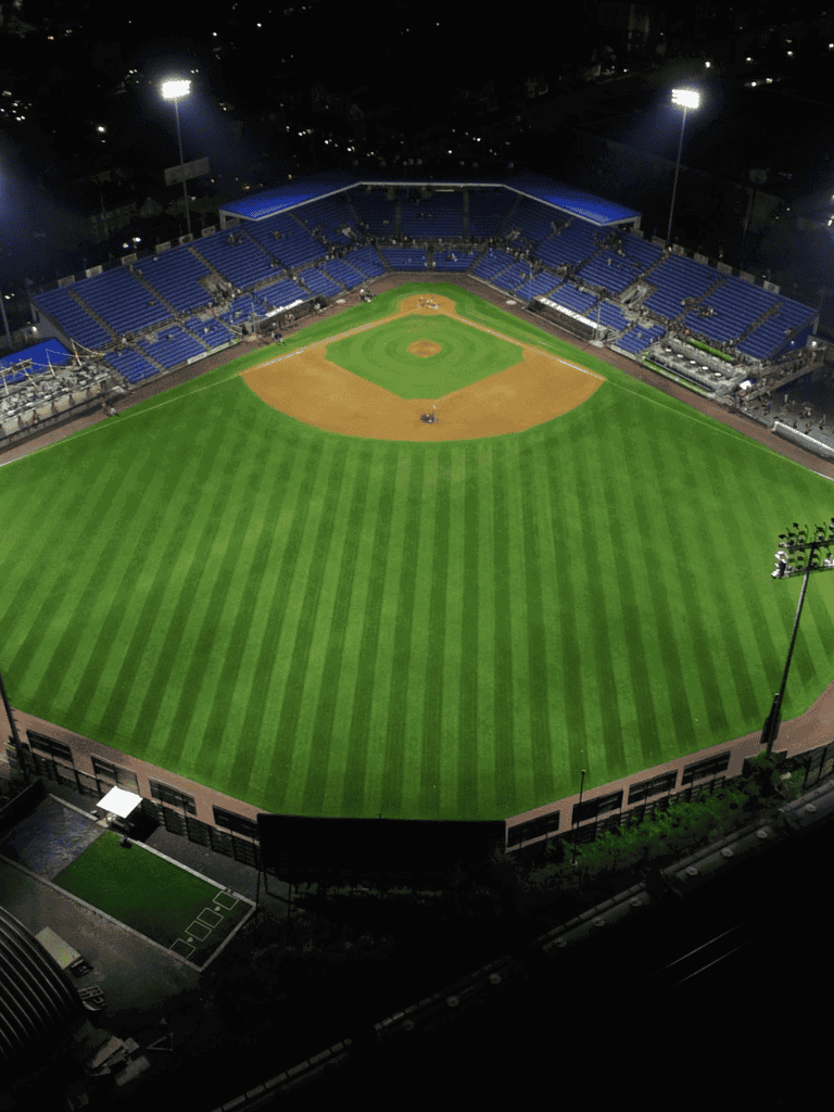 Baseball stadium at night, lighting up the field and seats, perfect for live sports events and entertainment.