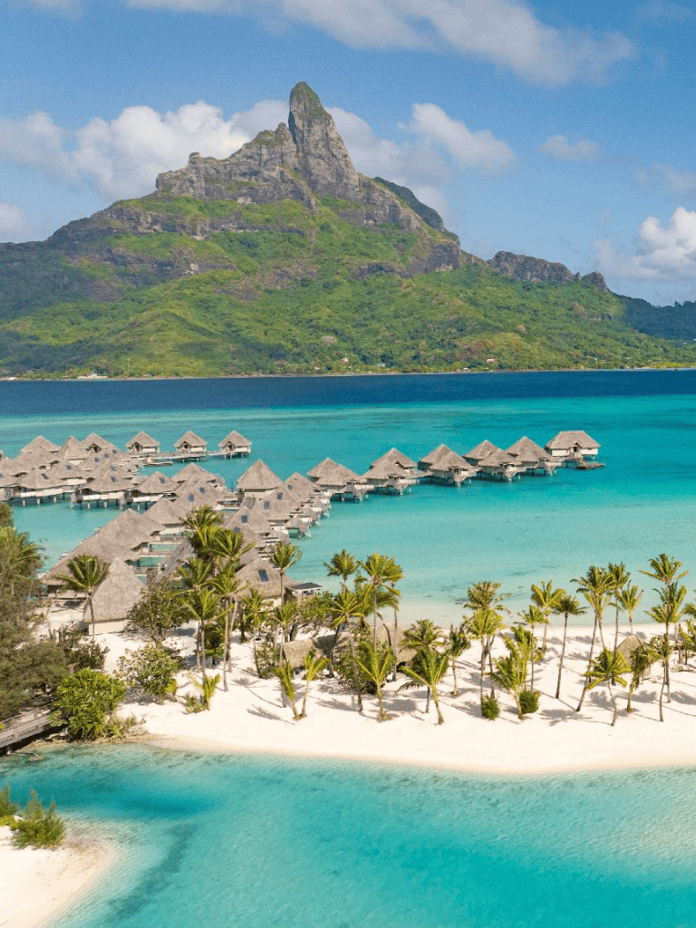 Overwater bungalows and lush tropical landscape at a luxury beach resort in Bora Bora.