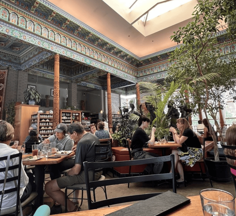 Enjoy a cozy, art-inspired dining experience at QuestForDirections in a beautifully decorated, lush indoor restaurant ambiance.