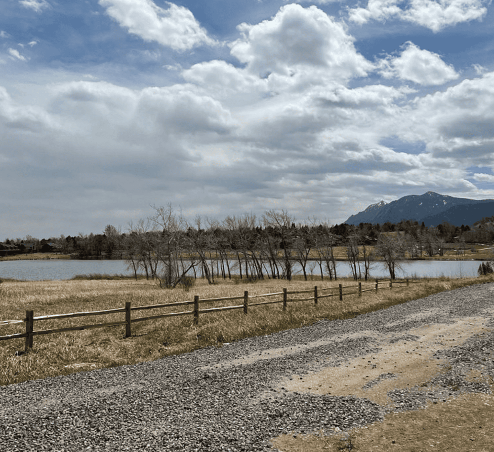Serene lake landscape with mountains and cloudy sky, ideal for outdoor adventure and nature exploration.