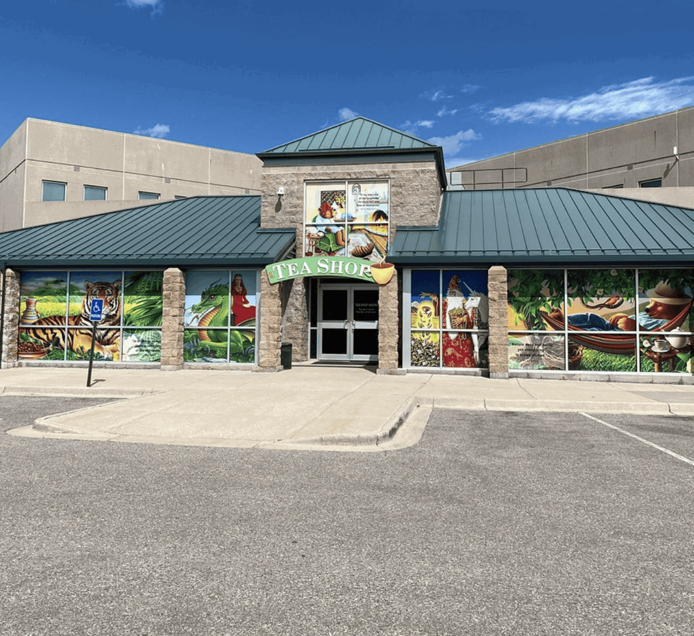 Colorful tea shop storefront with vibrant mural art and accessible parking, ideal for locals and visitors.