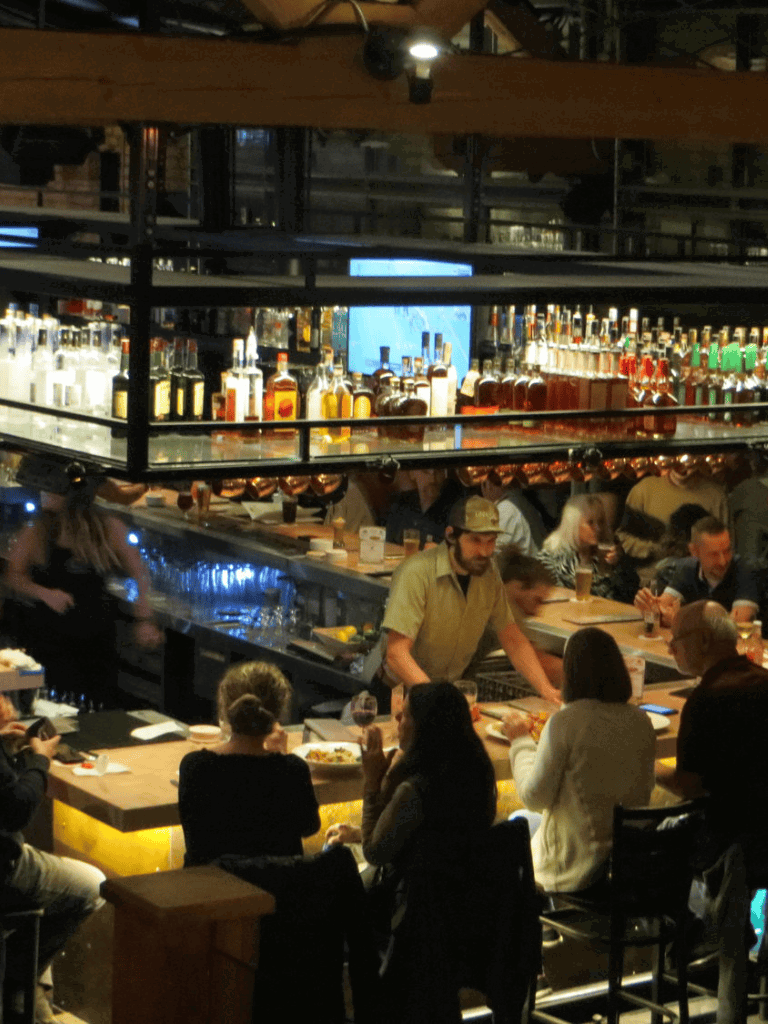 Whiskey bar at QuestForDirections restaurant showcasing a vibrant atmosphere and extensive liquor selection.