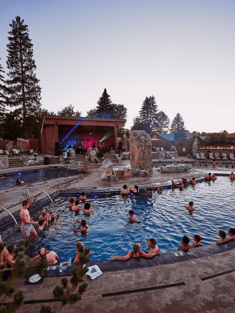 Relaxing outdoor hot spring pool with live music and scenic mountain views.