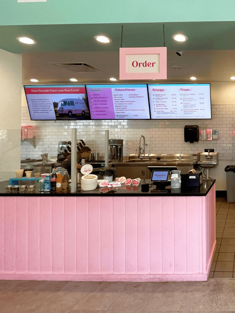 Delicious ice cream shop interior with pink décor and menu screens at QuestForDirections.