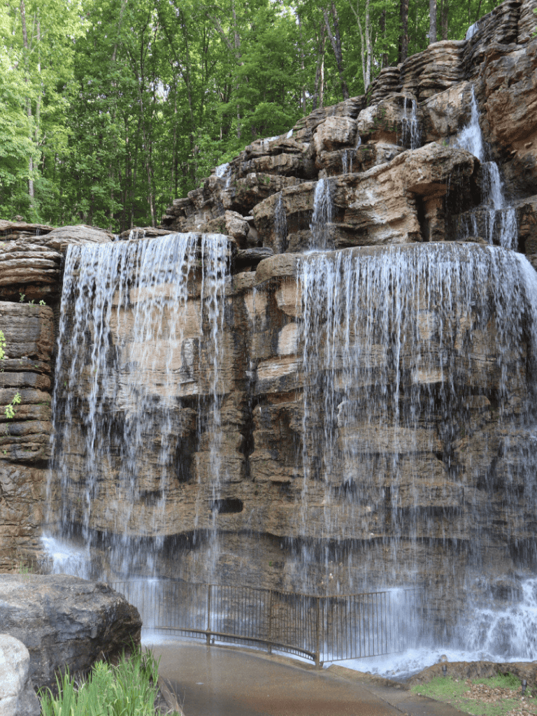 Waterfall cascading over rocks in lush green forest environment.
