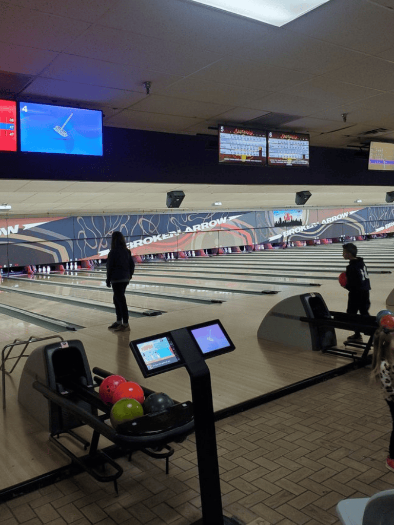 1. Bowling alley with children playing and digital scoreboards in the background.