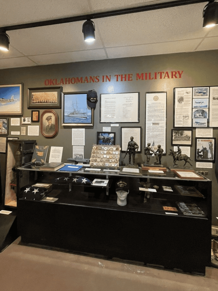 Oklahoma veterans military display with memorabilia, photos, and historical artifacts.