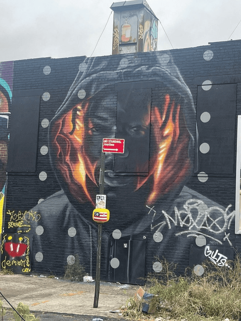 Vibrant mural graffiti art of a woman with hood on brick wall, urban street art, QuestForDirections.