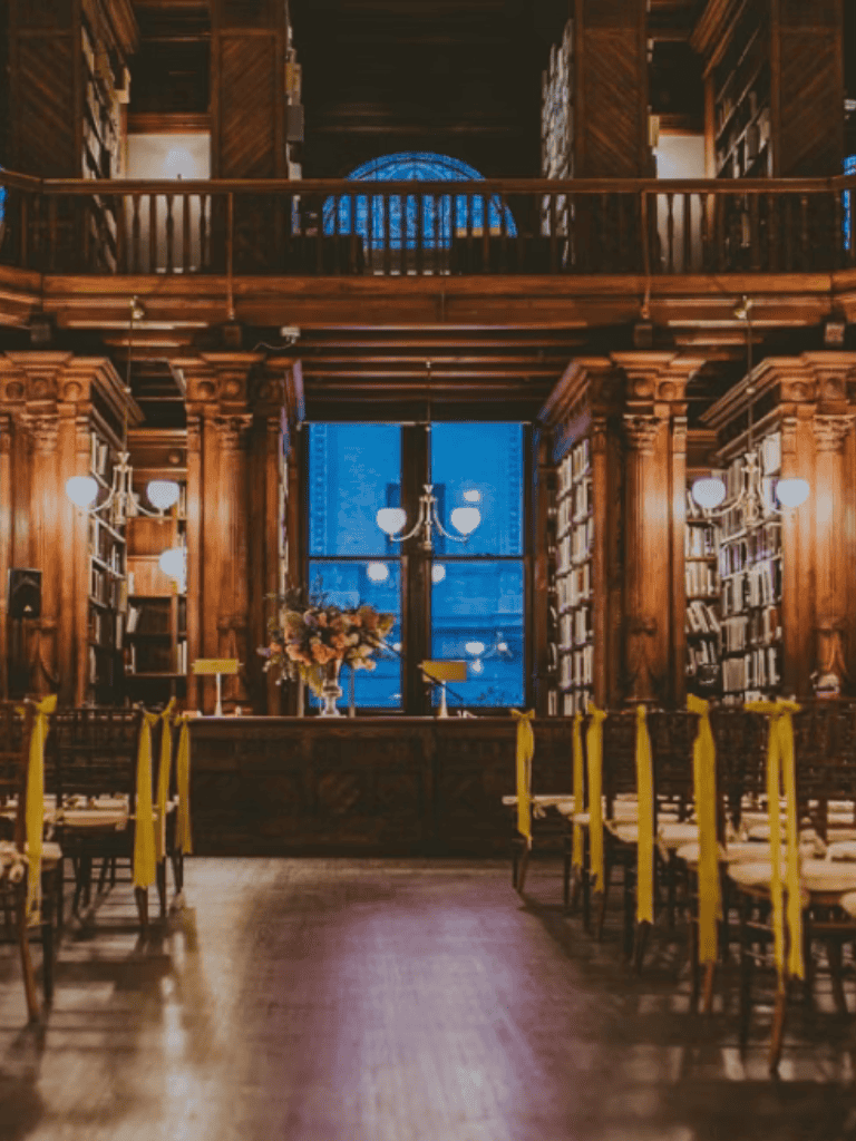 Ornate historic library interior with wooden shelves and grand windows.