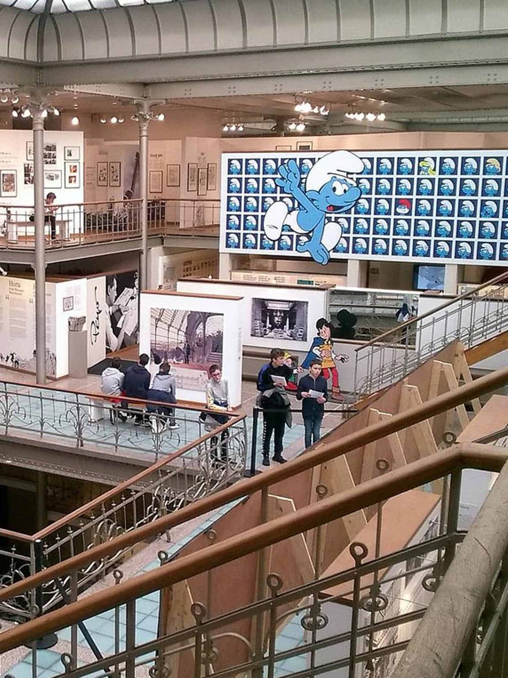 Colorful indoor art exhibit featuring Disney characters and visitors exploring museum displays.