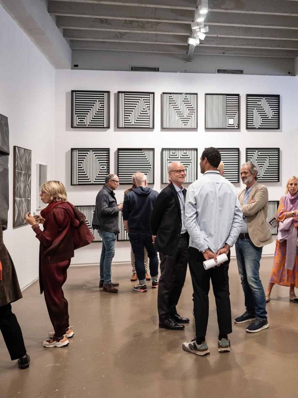 Vibrant art exhibit showcasing geometric abstract paintings in a modern gallery space.