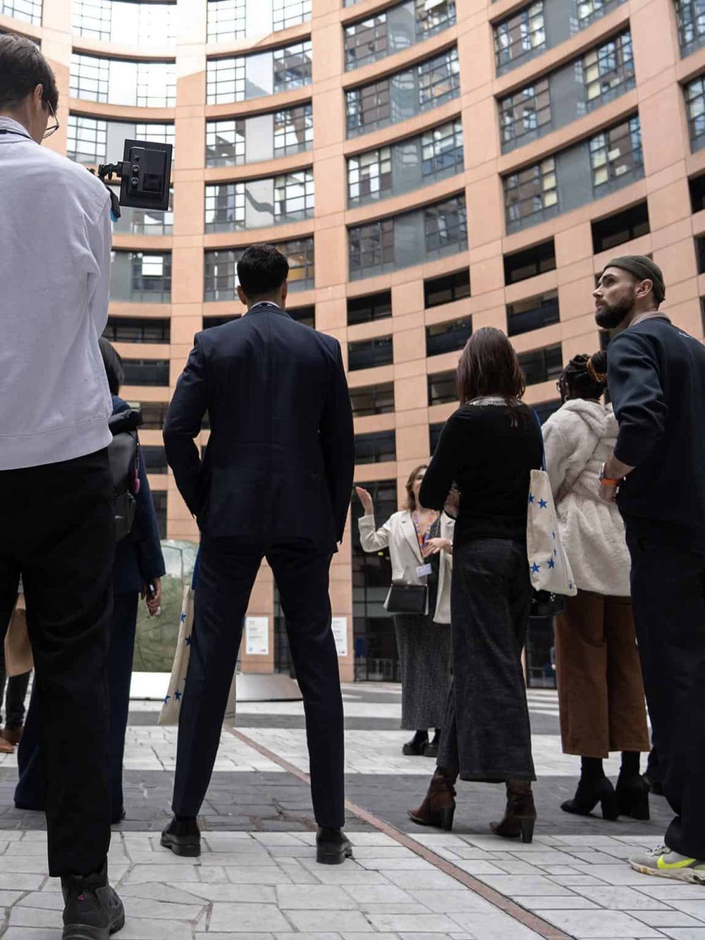 Group of diverse professionals attending an outdoor business event in front of a modern office building.