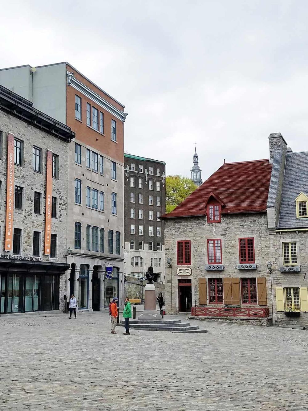 Charming historic square with colorful buildings and a statue, perfect for exploring Quebec City’s sightseeing and cultural attractions.