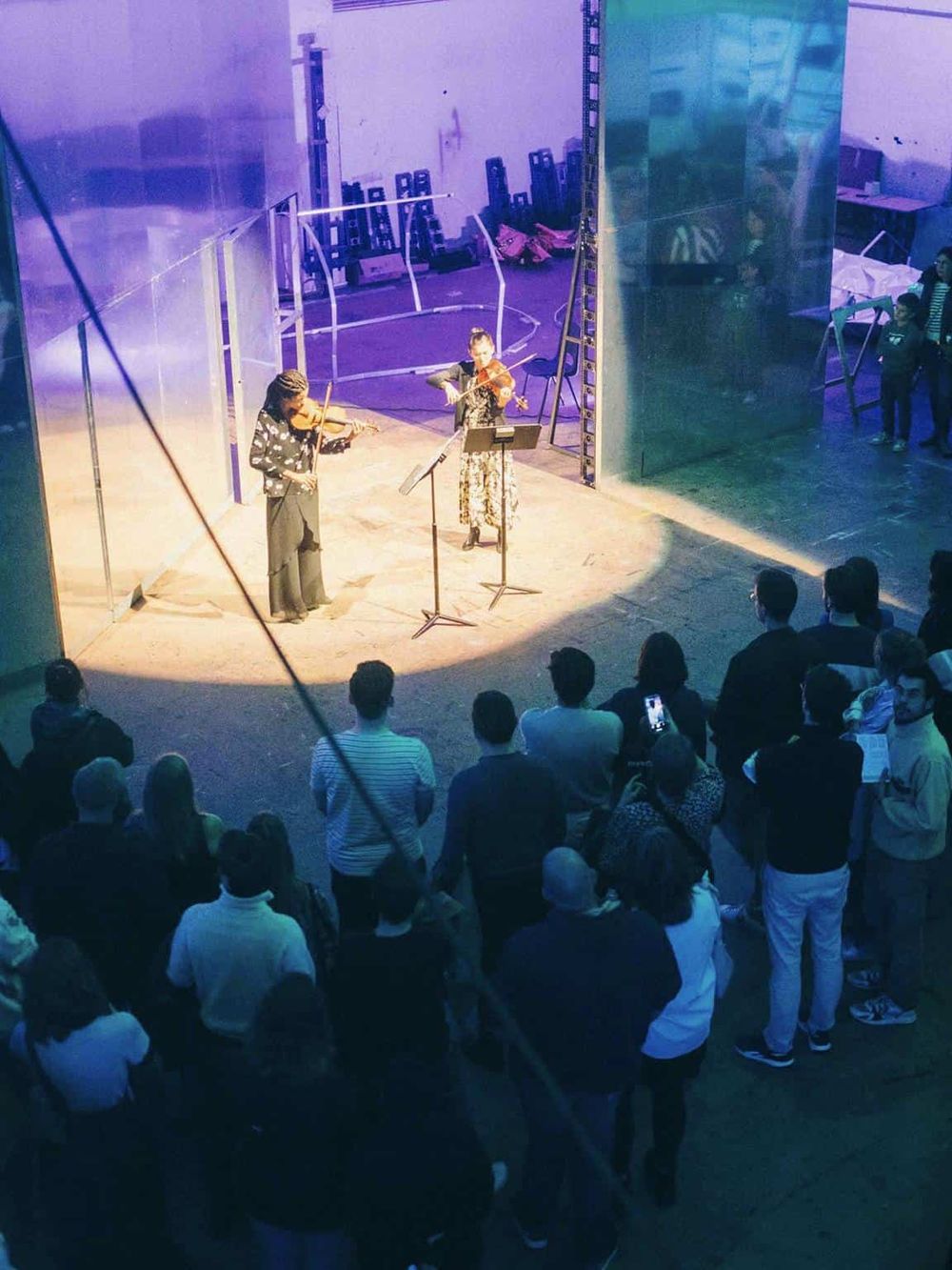 Violinists perform at QuestForDirections audience event, inspiring community through music and cultural expression.