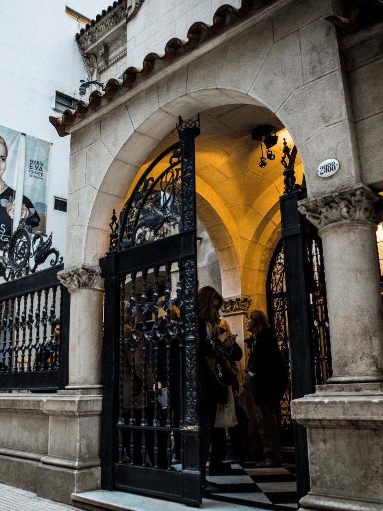 Elegant historic building entrance with ornate iron gates and stone columns in downtown.
