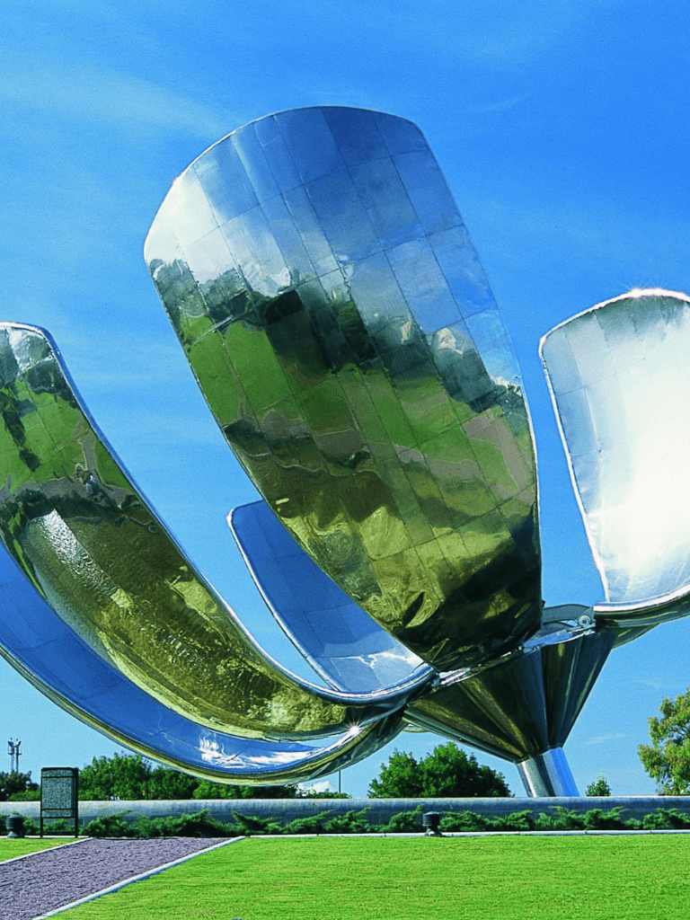Contemporary outdoor sculpture resembling a metallic flower at QuestForDirections. Iconic modern art piece reflecting sky and greenery.