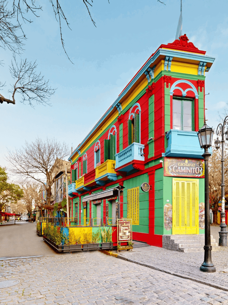 Vibrant colorful building with green, red, yellow, and blue accents on a city street scene.