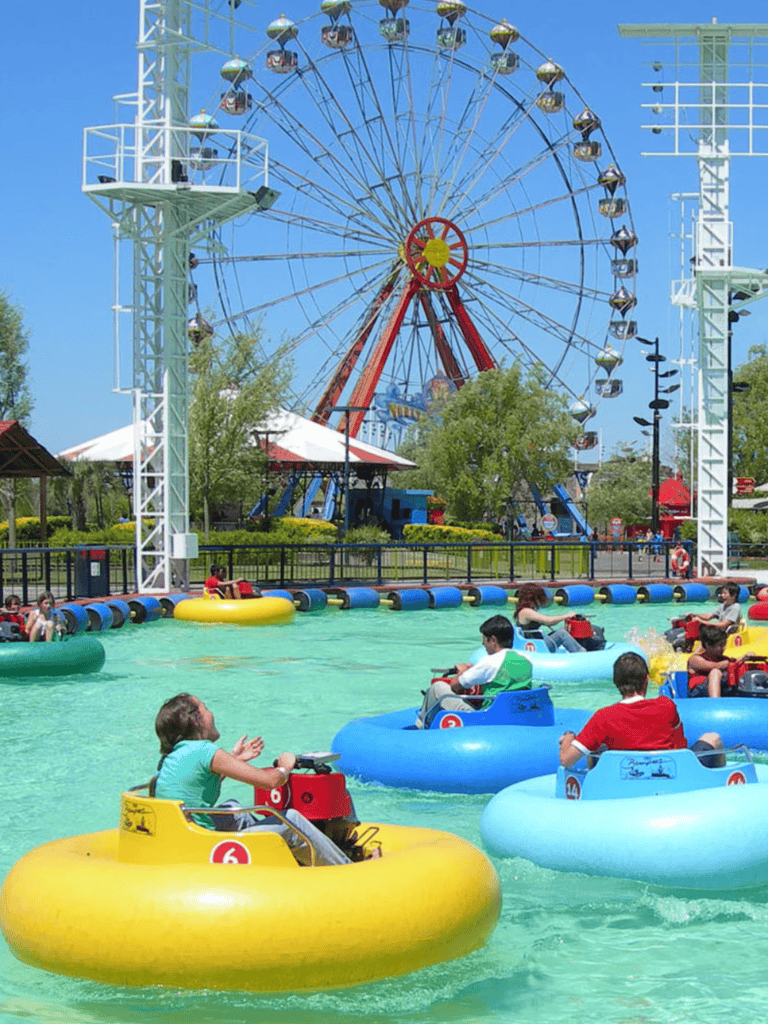 Amusement park with bumper boats and a large Ferris wheel in the background.