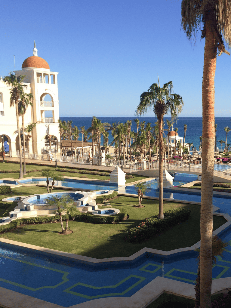 Luxurious seaside resort with palm trees, pool, and ocean view at QuestForDirections.