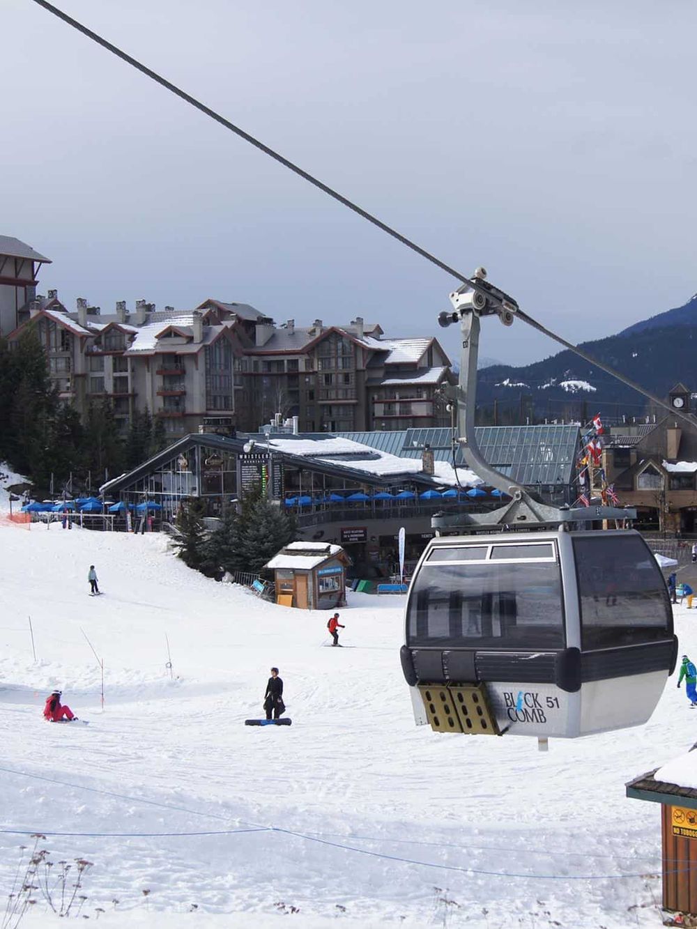 Cable car ride at winter ski resort with snow-covered slopes and mountain views.
