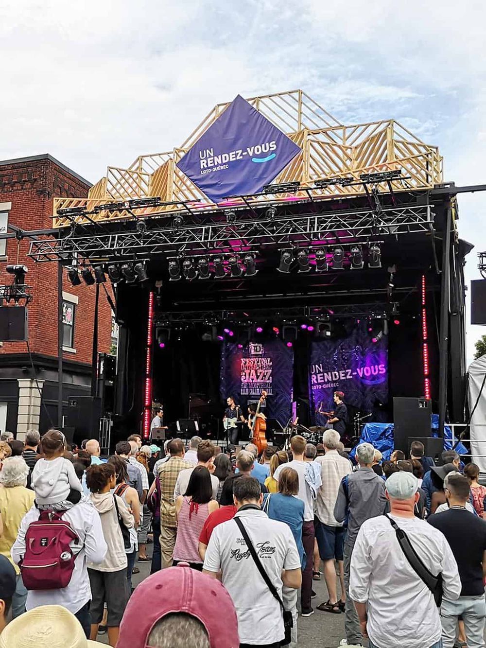 Live jazz festival performance with an outdoor stage, vibrant lighting, and a large audience enjoying the event.