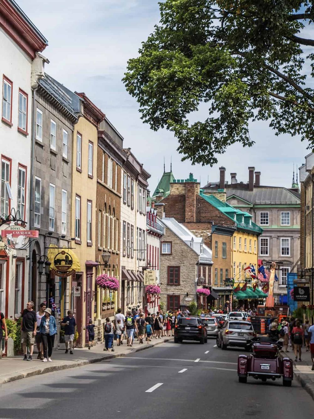 Charming historic street in Montreal with colorful buildings, pedestrians, and vibrant storefronts, perfect for exploring local culture and dining.
