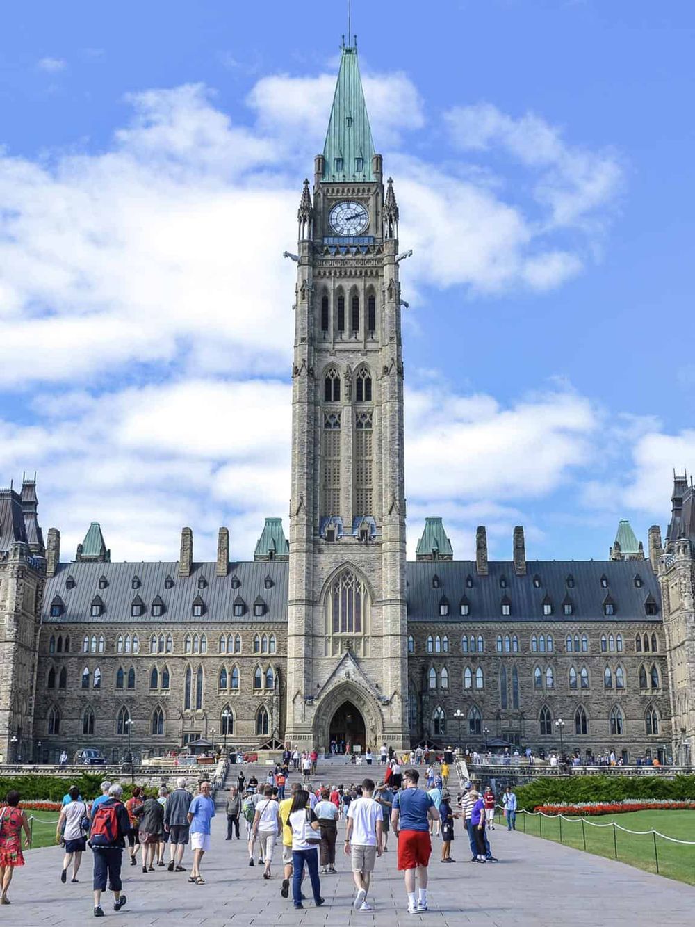 Tourists visiting Ottawa's historic Parliament Hill with the iconic clock tower, a central landmark and government seat.