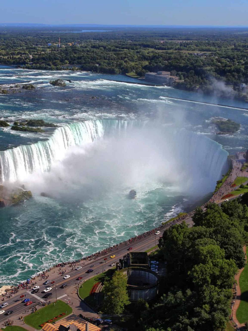 Vibrant aerial view of Niagara Falls showcasing cascading waterfalls and surrounding lush greenery.
