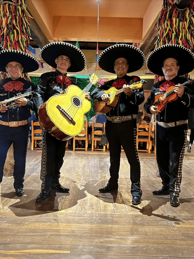 Colorful mariachi band performing traditional Mexican music at a festive event.