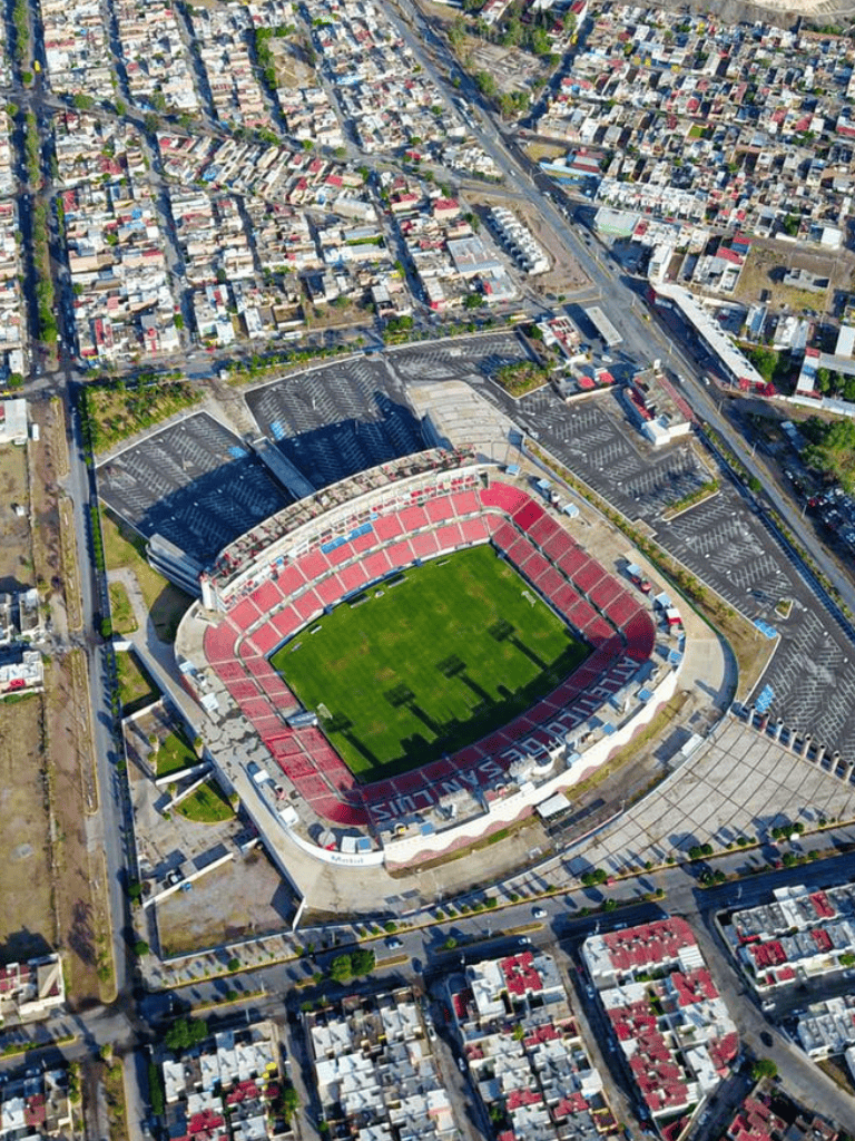 Aerial view of Quest for Directions stadium and surrounding urban area with parking lots and city streets.