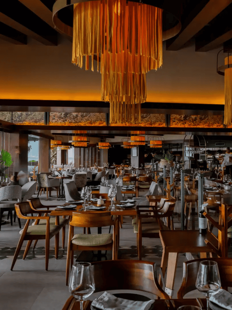 Elegant restaurant interior with modern lighting and wooden furniture, perfect for fine dining experience.